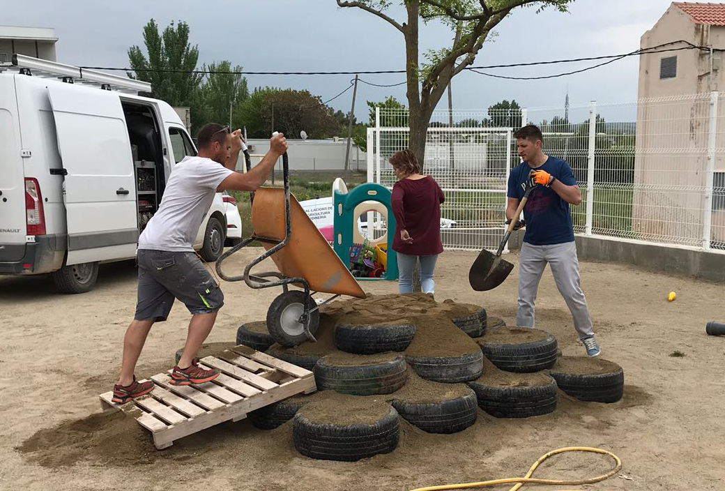 Mares i pares de la Llar d’Infants El Niu de Tàrrega instal·len nous jocs per a la mainada al pati del centre
