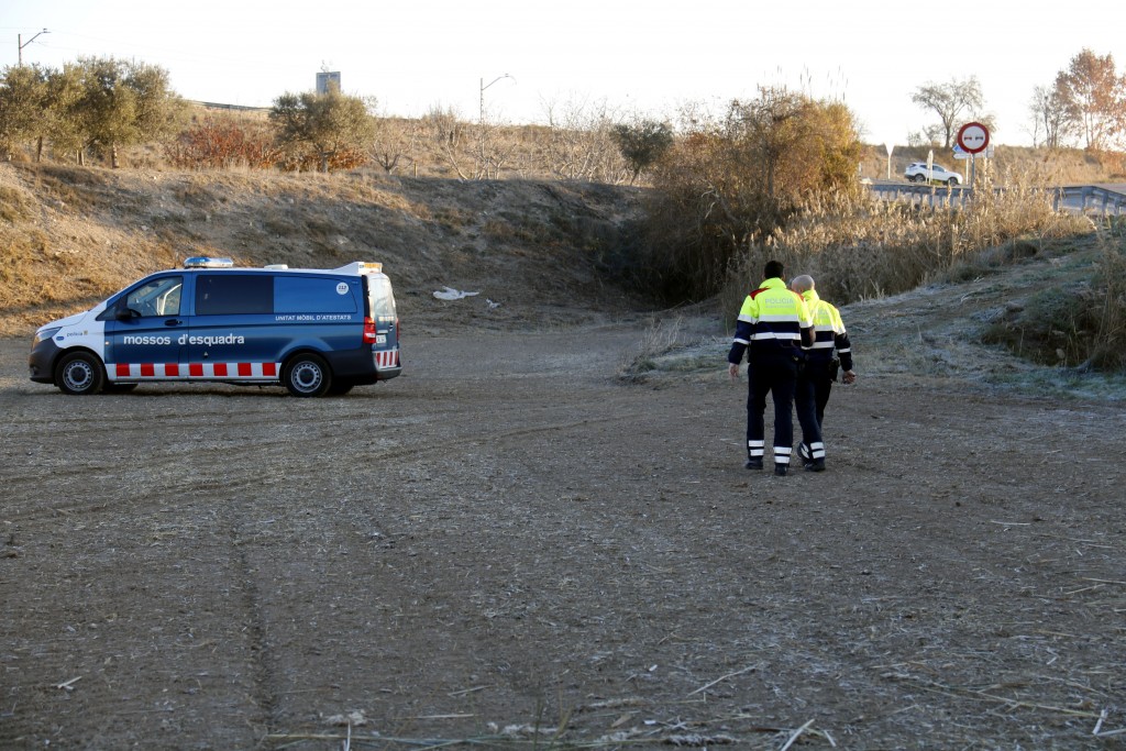Pla curt on es poden veure dos agents dels Mossos d'Esquadra al camp on ha caigut on cotxe que ha sortit de la via a Castellnou de Seana, el 4 de desembre de 2017. (Horitzontal)