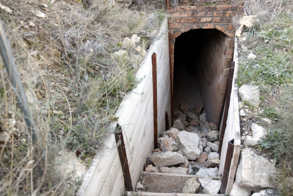 Pla obert on es poden veure un munt de pedres obstaculitzant l'entrada a un dels refugis de les trinxeres de Montgai, el 4 de gener de 2018. (Horitzontal)